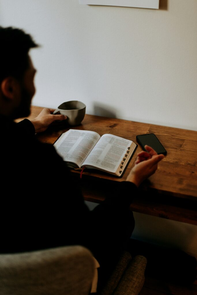 man reading a bible at a table